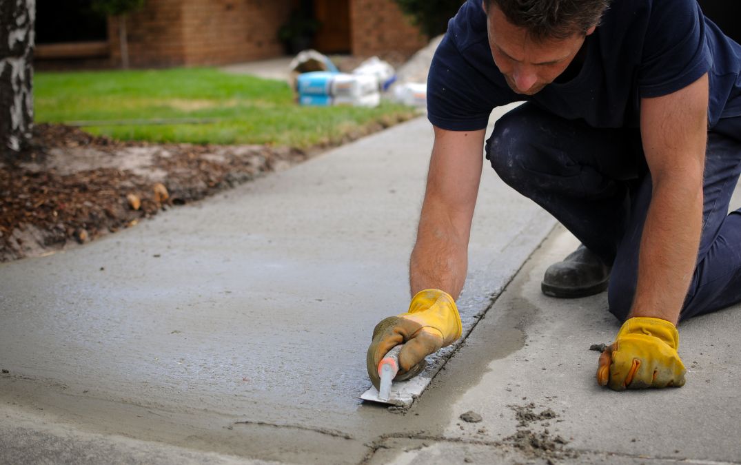 A man working on creating a concrete driveway.