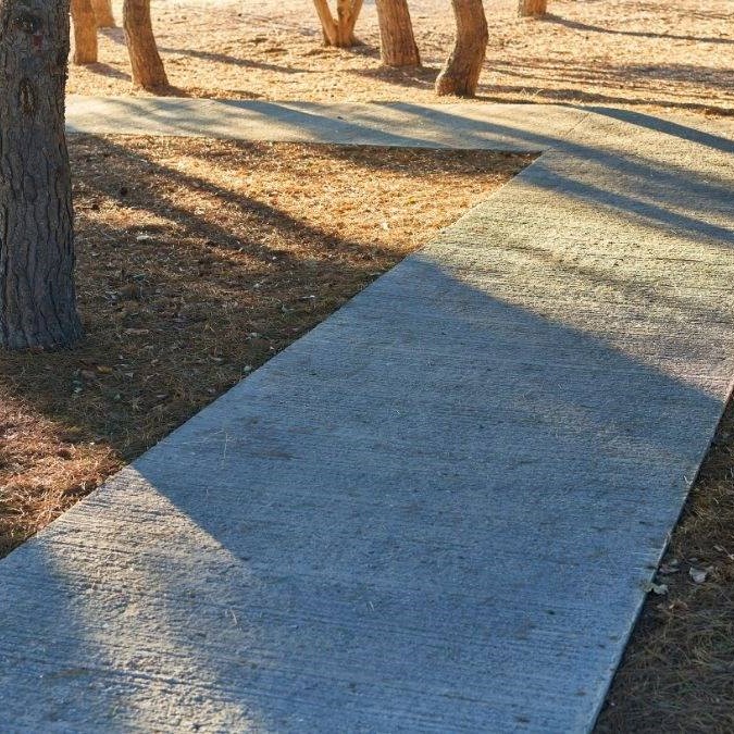 A recently completed concrete path in a public park.