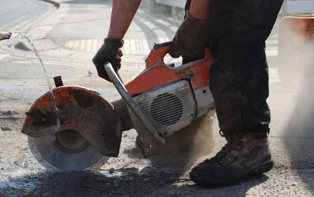 Angle grinder being used to remove concrete flooring.