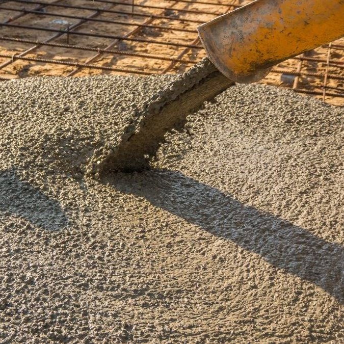 Concrete mix being poured onto sub base.