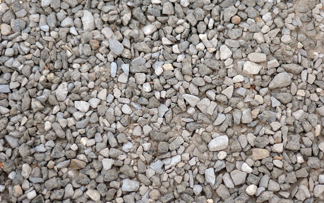 Gravel laid over the top of compressed soil, acting as reinforcement for fresh concrete.