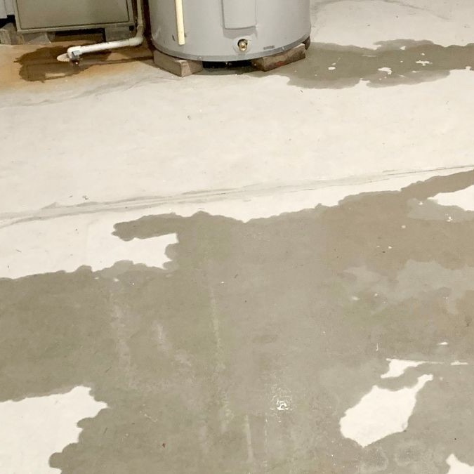 Wet concrete flooring where water has leaked.