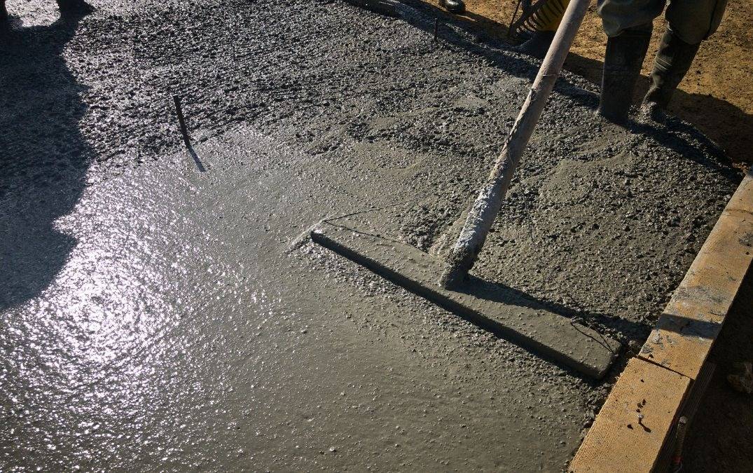 A bull float being used to smooth wet concrete.