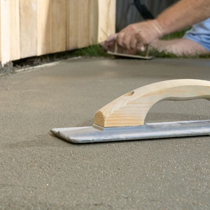 Hand float being used to smooth concrete.