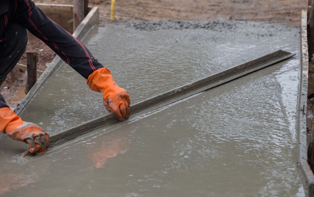 An aluminium screed board leveling concrete.