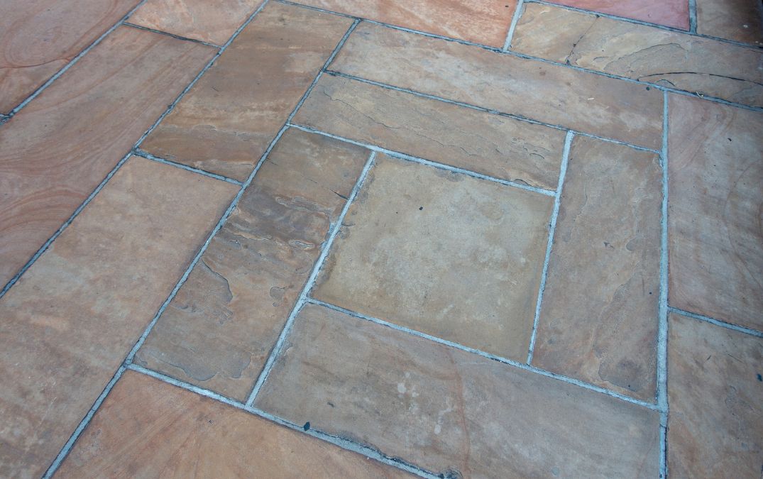 Older slate flooring that has not been sealed properly, rectangular pattern.