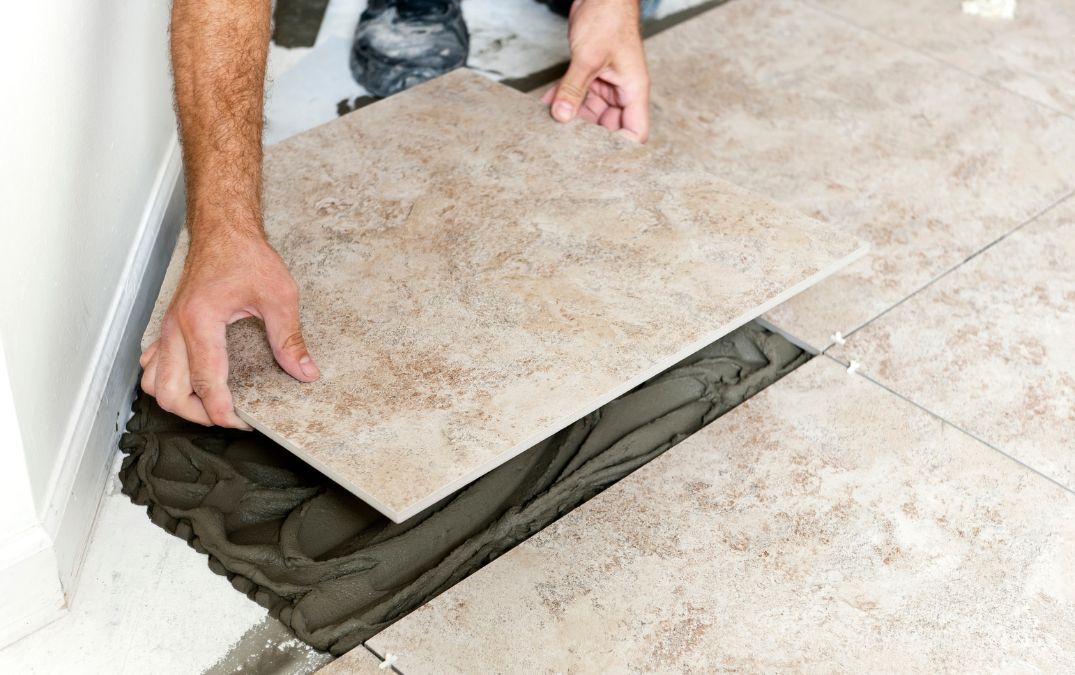 Carpet padding being tacked down onto concrete flooring.