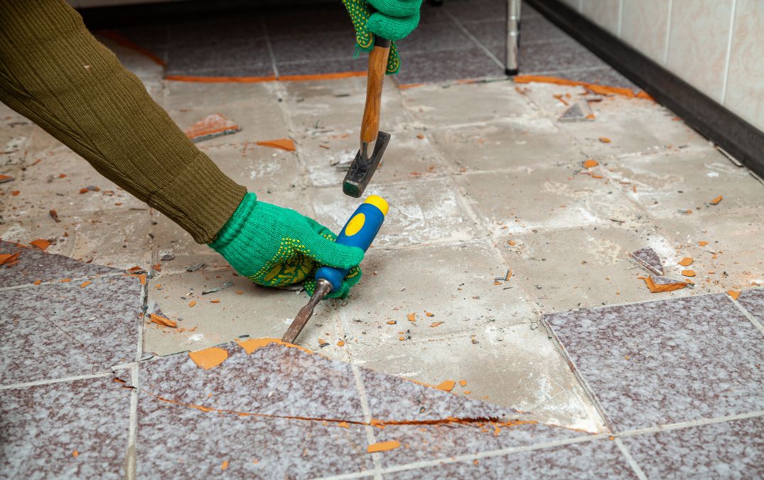 Tiles being removed from a concrete floor.